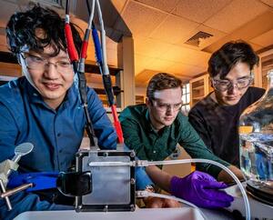  Professor Xiao Su, left, graduate student Stephen Cotty, center, and postdoctoral researcher Kwiyong Kim have developed an energy-efficient device that selectively absorbs a highly toxic form of arsenic in water and converts it into a far less toxic form.